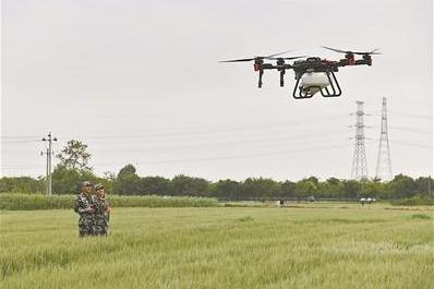 马鞍山市民兵志愿者操作无人机喷洒农药